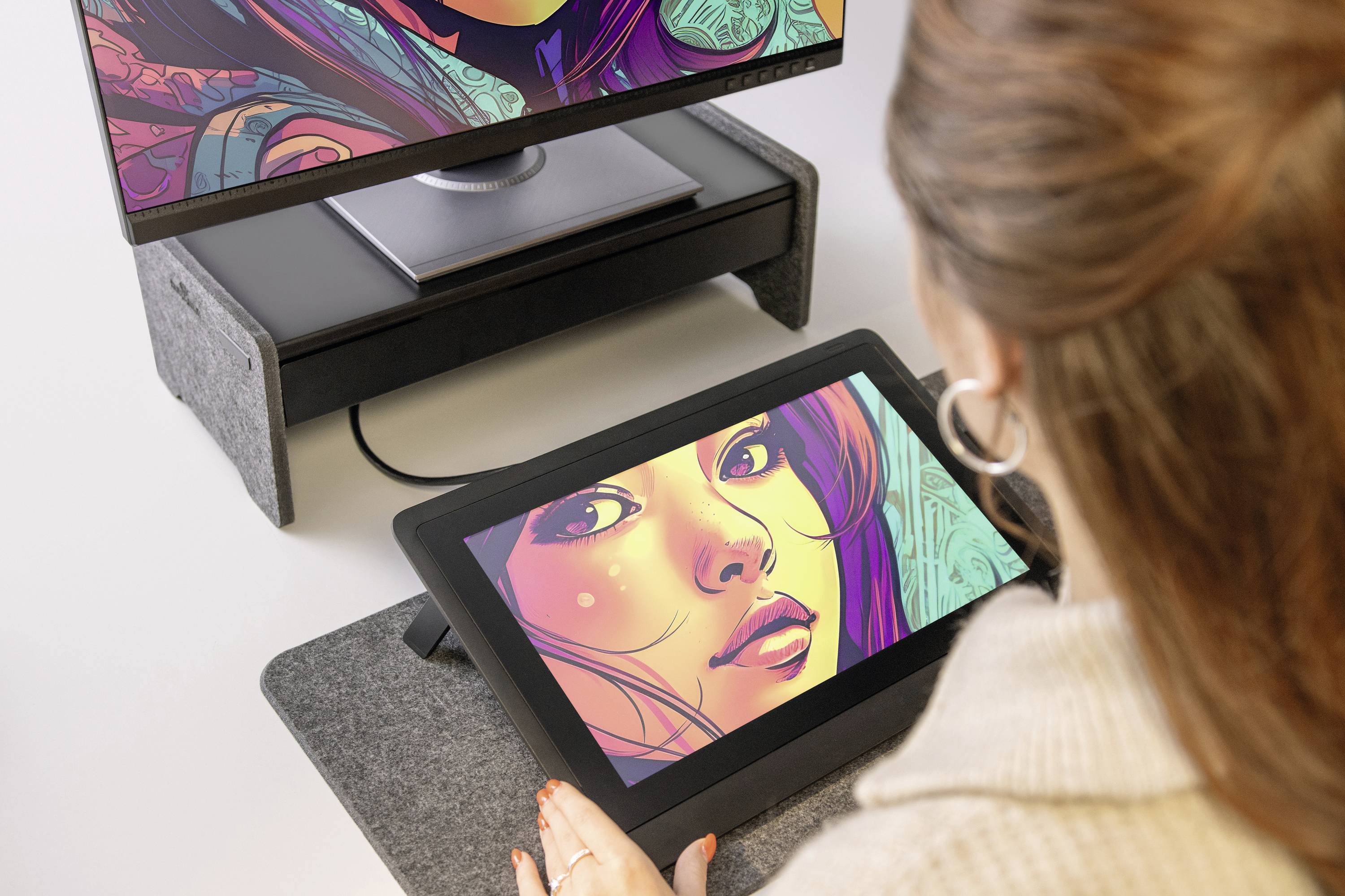 Een vrouw werkt aan een grafisch tablet, ontwerpt een kleurrijk portret op de computer. Hooggeconcentreerd, met de desktop op de achtergrond zichtbaar.