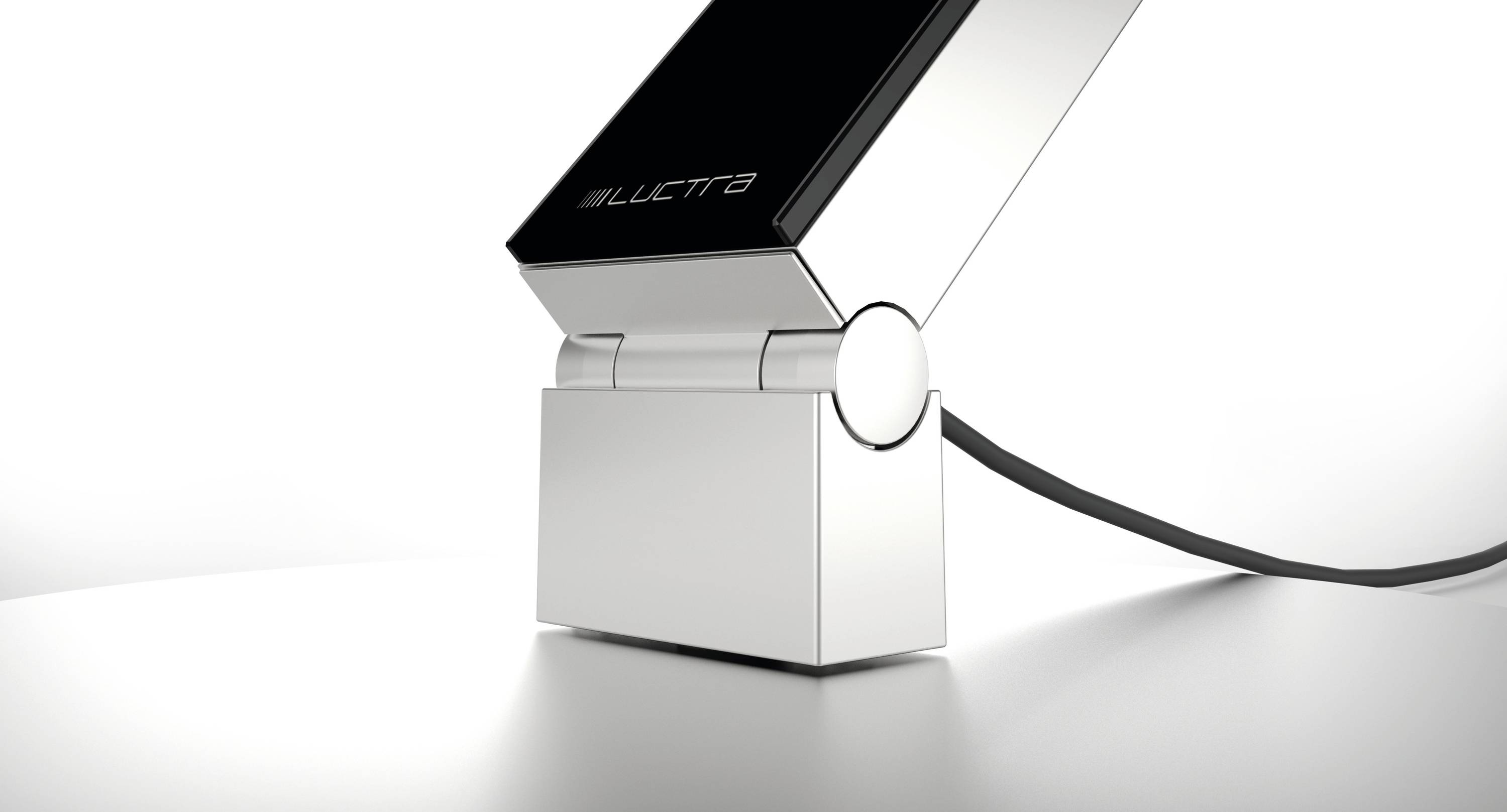 Een modern, zilver elektronisch apparaat met een zwart scherm is via een kabel verbonden. Het staat op een glanzende witte ondergrond.