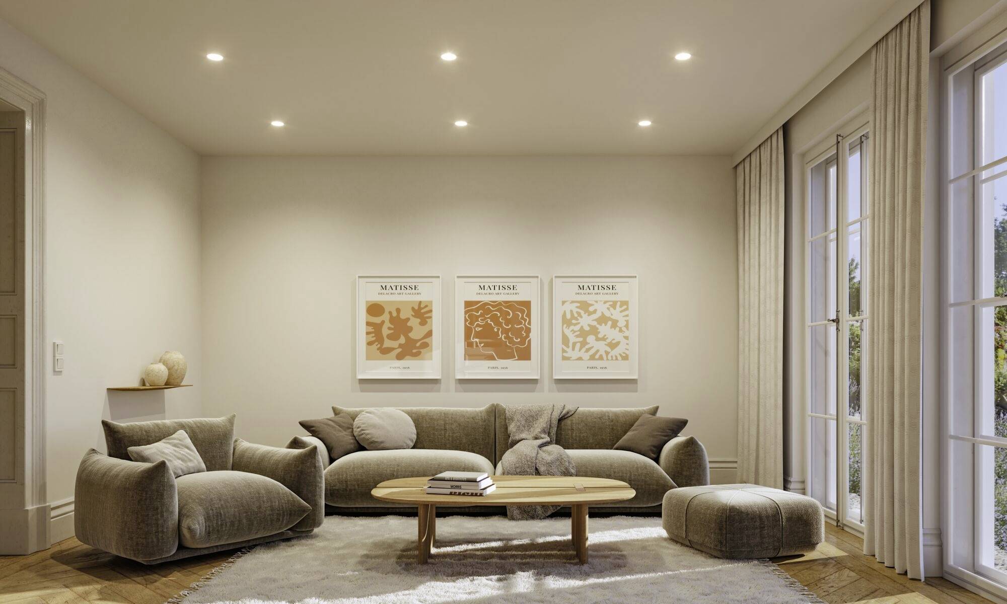 Een modern woonkamer met een grijze bank, twee fauteuils, een houten salontafel en een vloerkleed. Drie kunstwerken hangen aan de muur.
