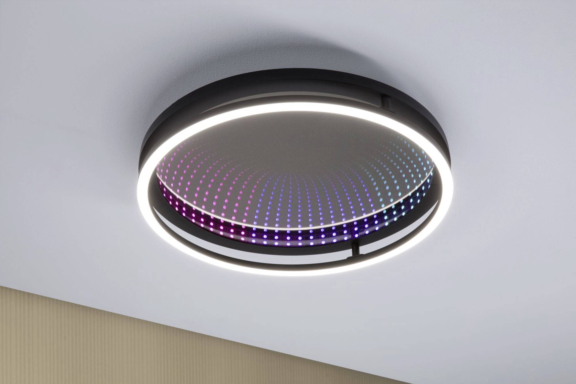 Ronde plafondlamp met een kleurrijk LED-patroon in het midden en een verlichte rand. Modern, decoratief design.