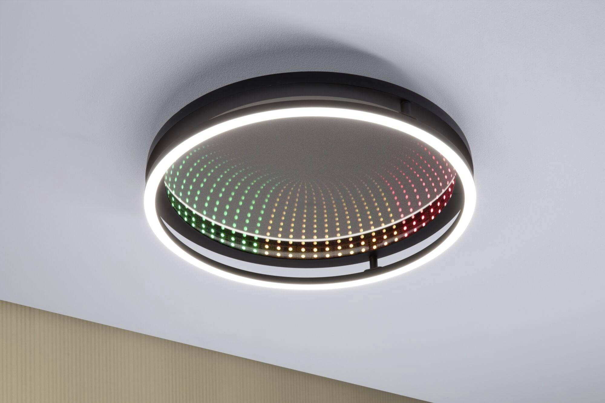 Ronde plafondlamp met een verlichte ring en een binnenpatroon van LED's in groenachtige en roodachtige tinten.