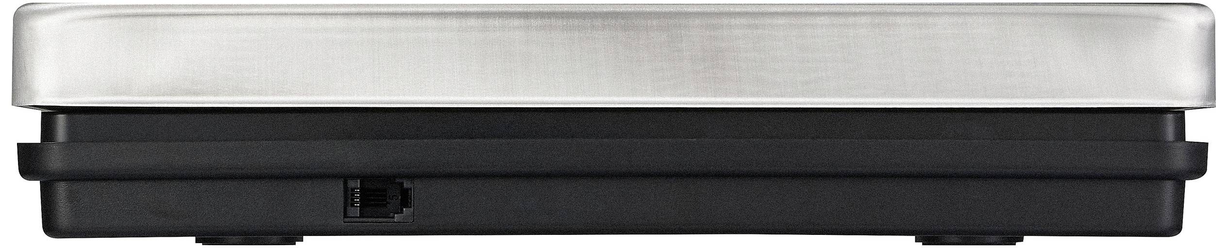 Zijaanzicht van een plat, rechthoekig apparaat met een metalen bovenkant en een zwarte basis. Bevat een kleine opening of aansluiting aan de zijkant.