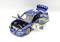 Een blauwe modelauto met open deuren en motorkap. De auto draagt het nummer 7 en heeft rallystickers.