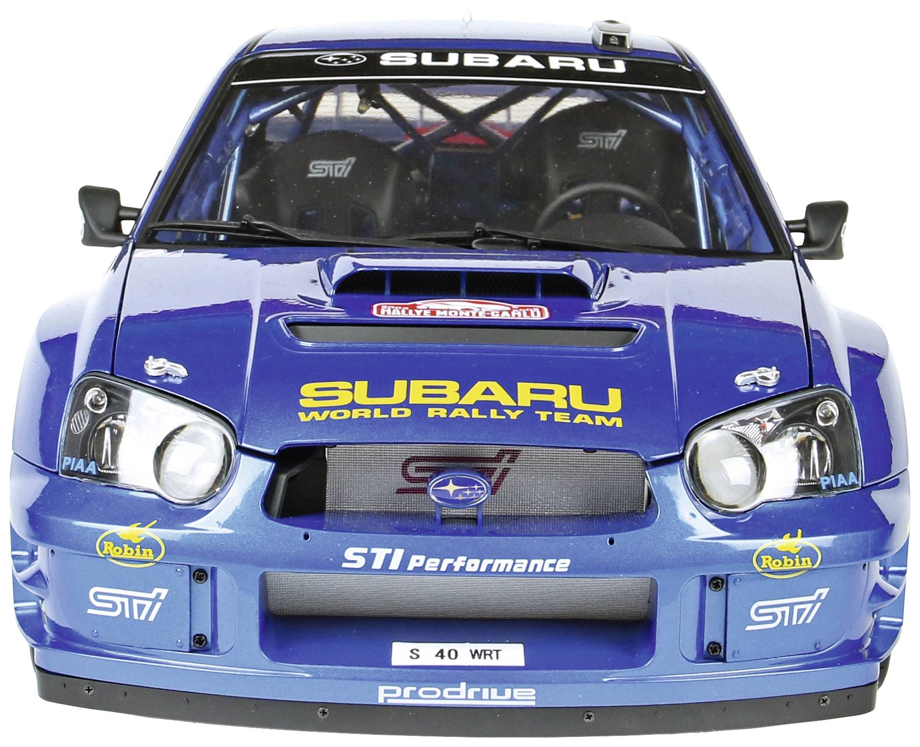 Een blauwe rallywagen met 'Subaru World Rally Team' en 'STI Performance' logo's op de voorkant. Racestriping en koplampen zichtbaar.