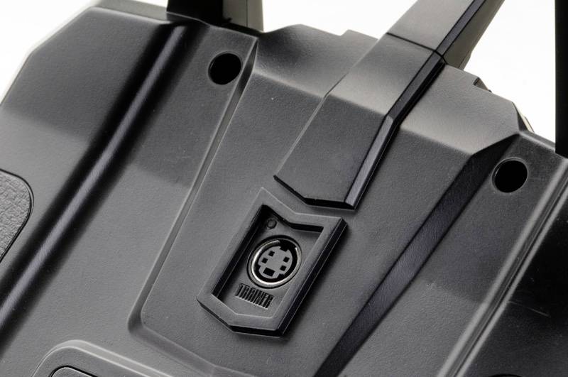 Zwarte kunststof aansluiting van een afstandsbediening met modulaire verbindingsplaats en houder, close-up bovenaanzicht.