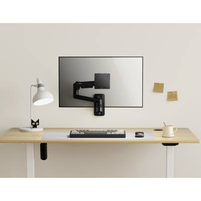 Een minimalistische bureautafel met een lamp, een wit muismat, een mok en een toetsenbord. Een monitorarm zonder monitor is aan de muur bevestigd.