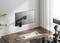 Een moderne bureau met een houten oppervlak, met daarop een toetsenbord en smartphone. Aan de muur is een verstelbare monitorsteun bevestigd.