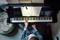 Een persoon speelt piano en leest muzieknoten die op de muziekstandaard liggen. Het perspectief is van bovenaf, met de focus op handen en toetsen.