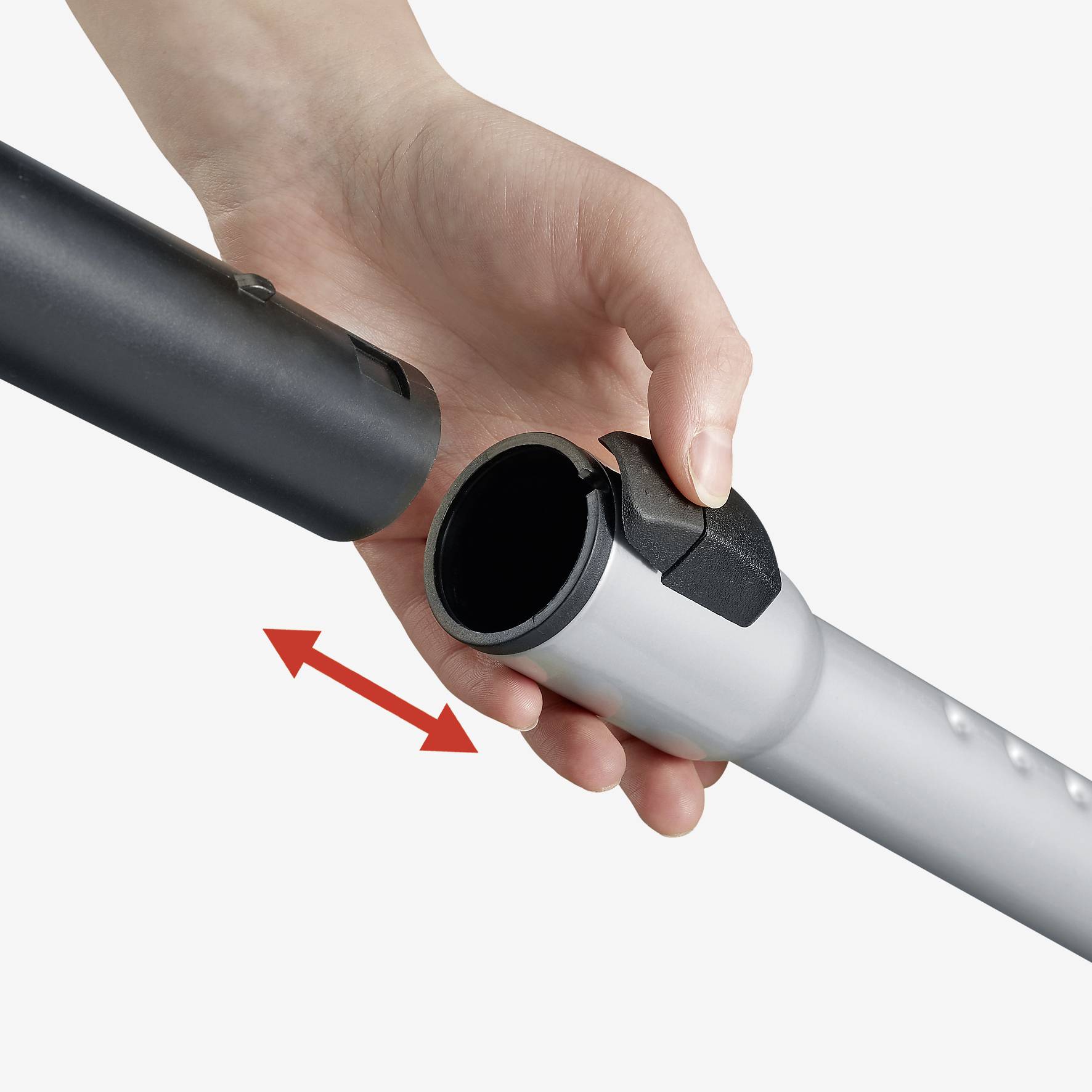 Een hand houdt een metalen staaf vast en wijst naar een verbinding met een pijl die een insteekmotie aangeeft.