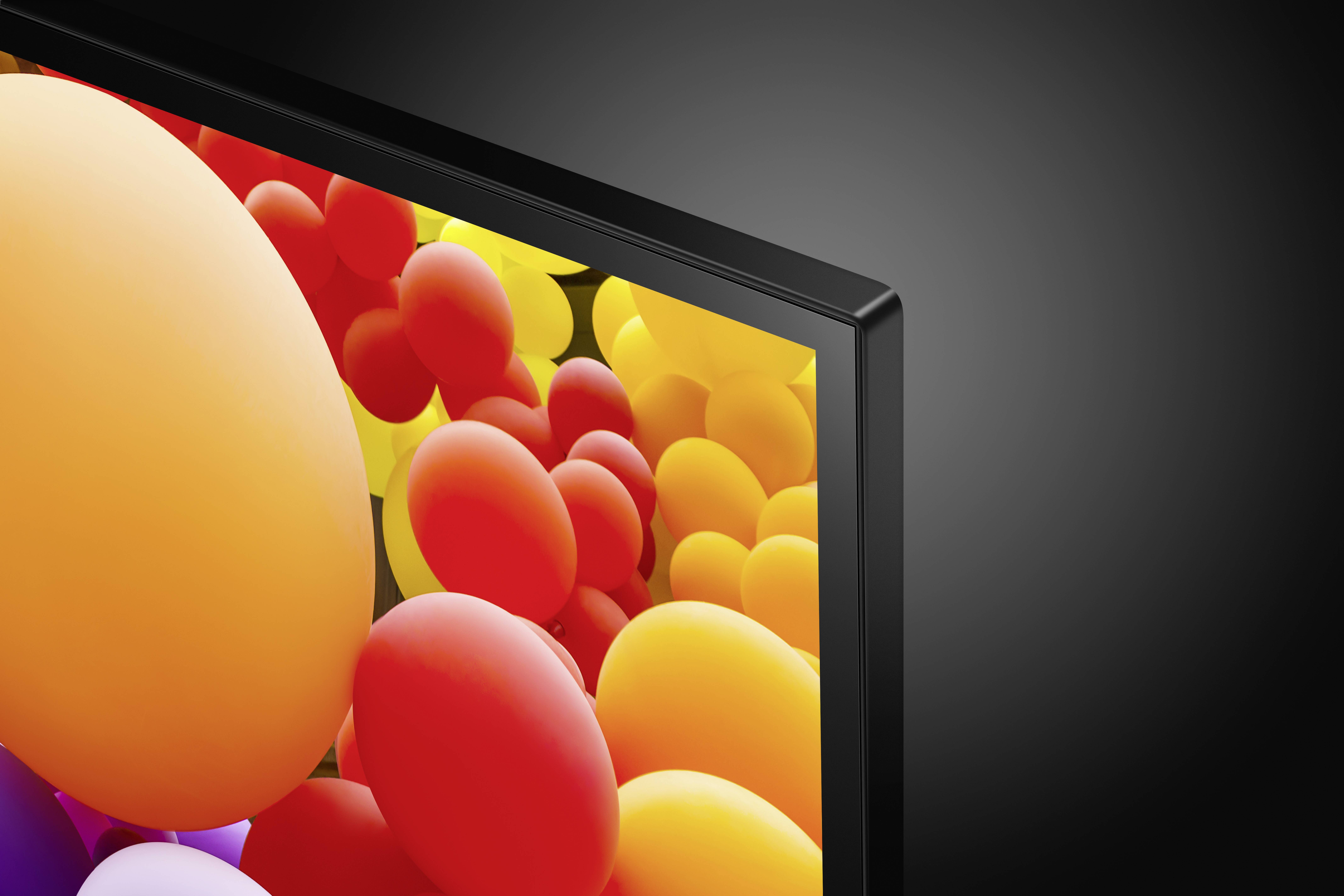 Een televisiebeeldscherm toont een levendig beeld van veel kleurrijke ballonnen in rood, geel en oranje op een zwarte achtergrond.