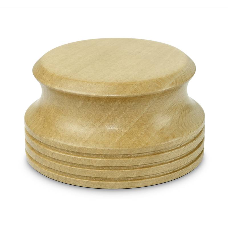 Een ronde, houten honing roerstok met geribde structuur staat rechtop.