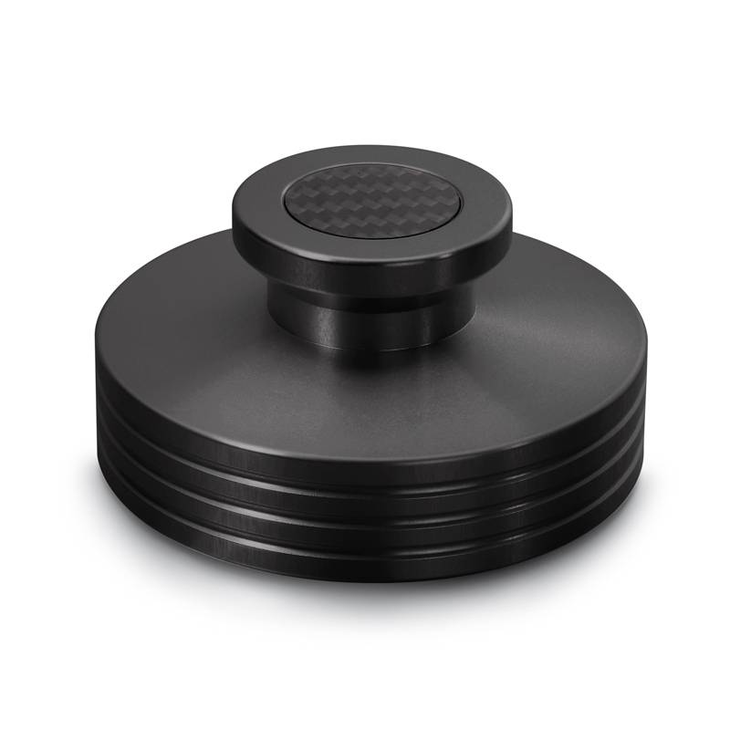 Een zwart, cilindervormig object met een gegroefde oppervlakte en een afgeplat bovenste deel. Het zou een onderdeel of accessoire kunnen zijn.