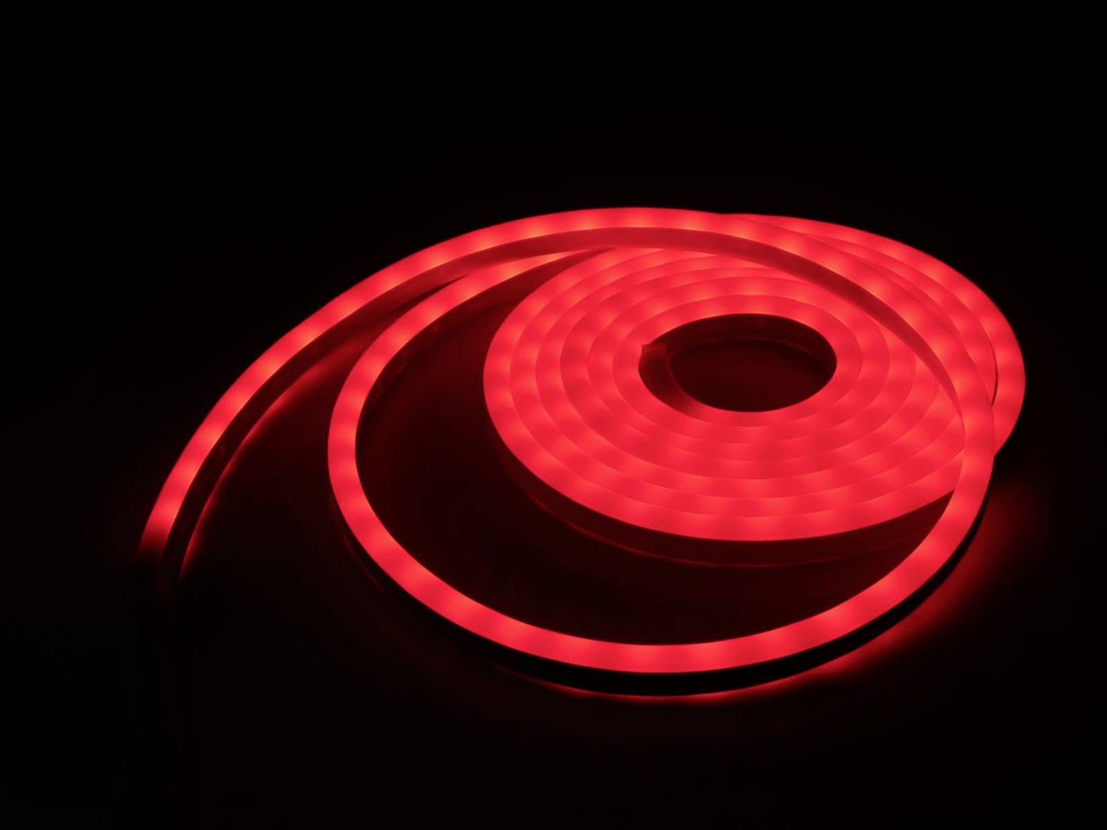 Een oplichtende LED-lichtbalk die zich in een spiraalvormige configuratie bevindt. De lichtbalk straalt in een levendig rood.