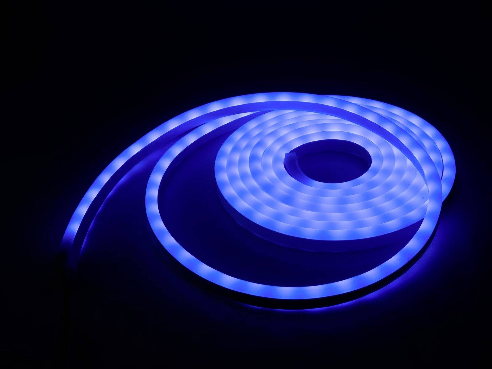 Een stralende, blauwe LED-lichtstreep is spiraalvormig gerangschikt op een donker oppervlak.