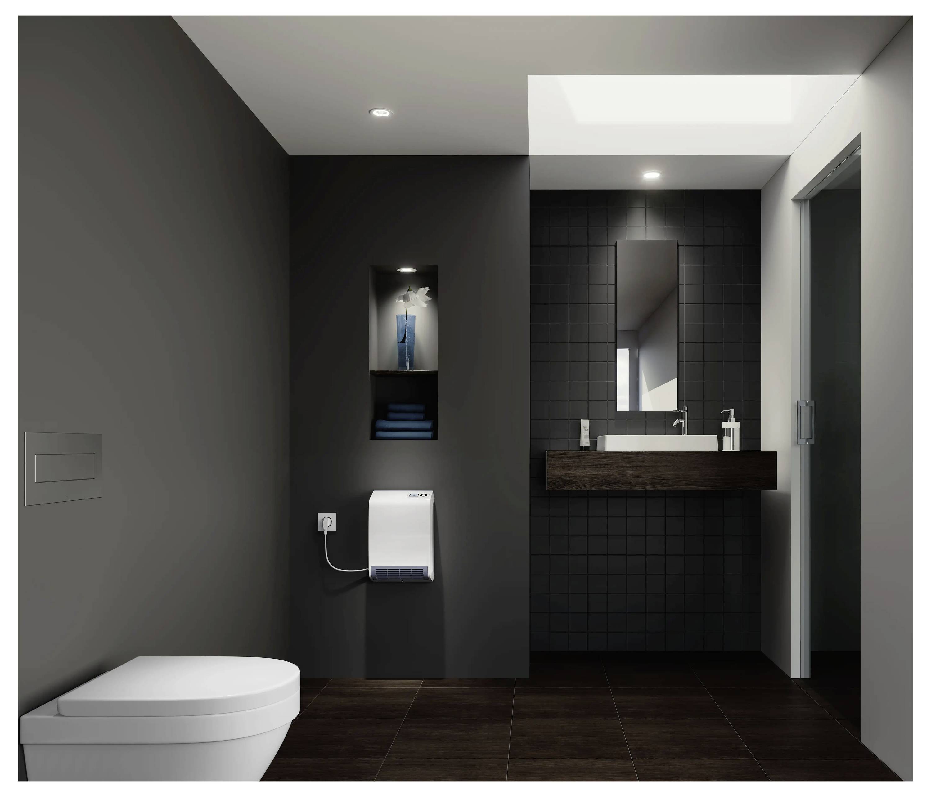 Een modern, minimalistisch badkamer met donkere muren, met een wit toilet, een klein wastafel met spiegel, en een nis met toiletartikelen.