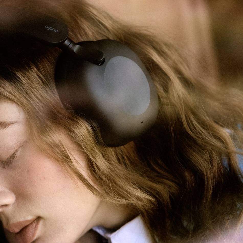 Een persoon luistert naar muziek met koptelefoon; ontspannen, gesloten ogen; rustige atmosfeer.