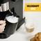 Een hand schuimt melk in een kan met een espressomachine. Rechtsboven is een geel veld met de tekst 'Melkstoommond'.