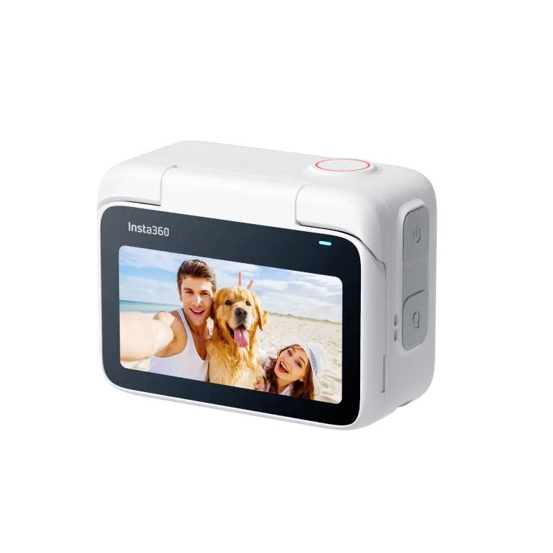 Witte camera met touchscreen toont een selfie van een man, een vrouw en een hond op het strand. Knoppen aan de zijkant.