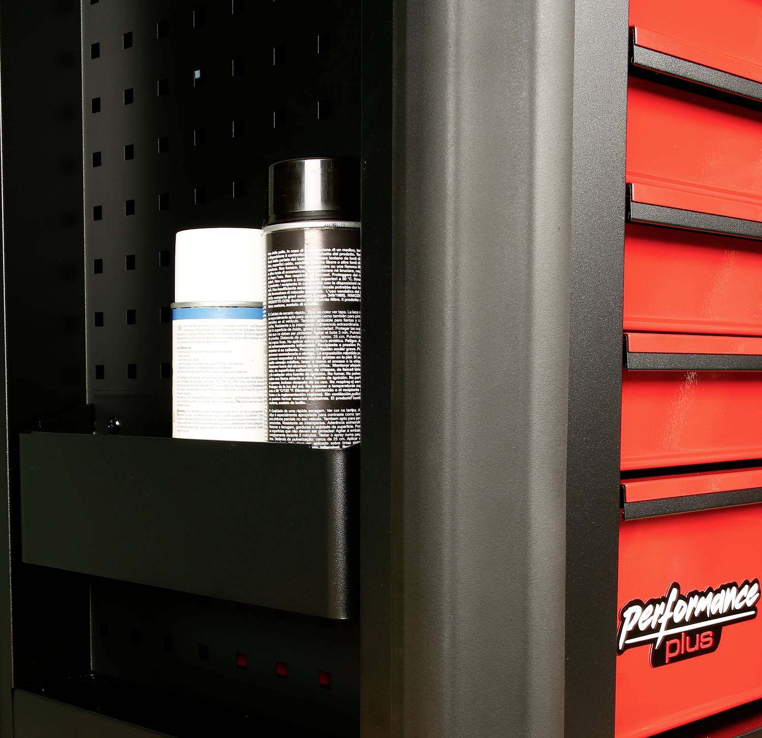 Een zwarte metalen kast met rode laden. Twee flessen staan op een zijplank in de kast.