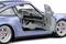 Zilveren auto met geopende bestuurdersdeur; toont interieur met stuurwiel, versnellingspook en dashboard-details.
