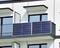 Zonnepanelen op de balustrade van een balkon van een modern woongebouw. De openslaande balkondeur wijst op gebruik of installatie.