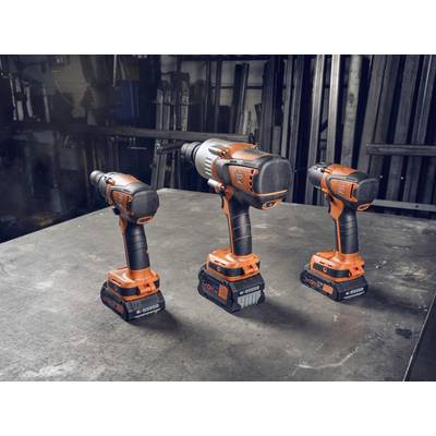 Drie oranje elektrische boormachines staan naast elkaar op een werkbank in een werkplaats. Op de achtergrond zijn metalen onderdelen zichtbaar.