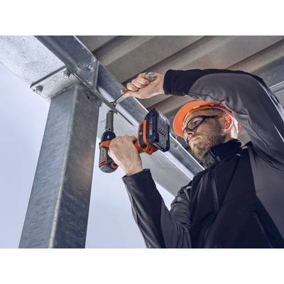 Een bouwvakker met veiligheidshelm gebruikt een accuschroevendraaier om een metalen trapleuning te bevestigen.
