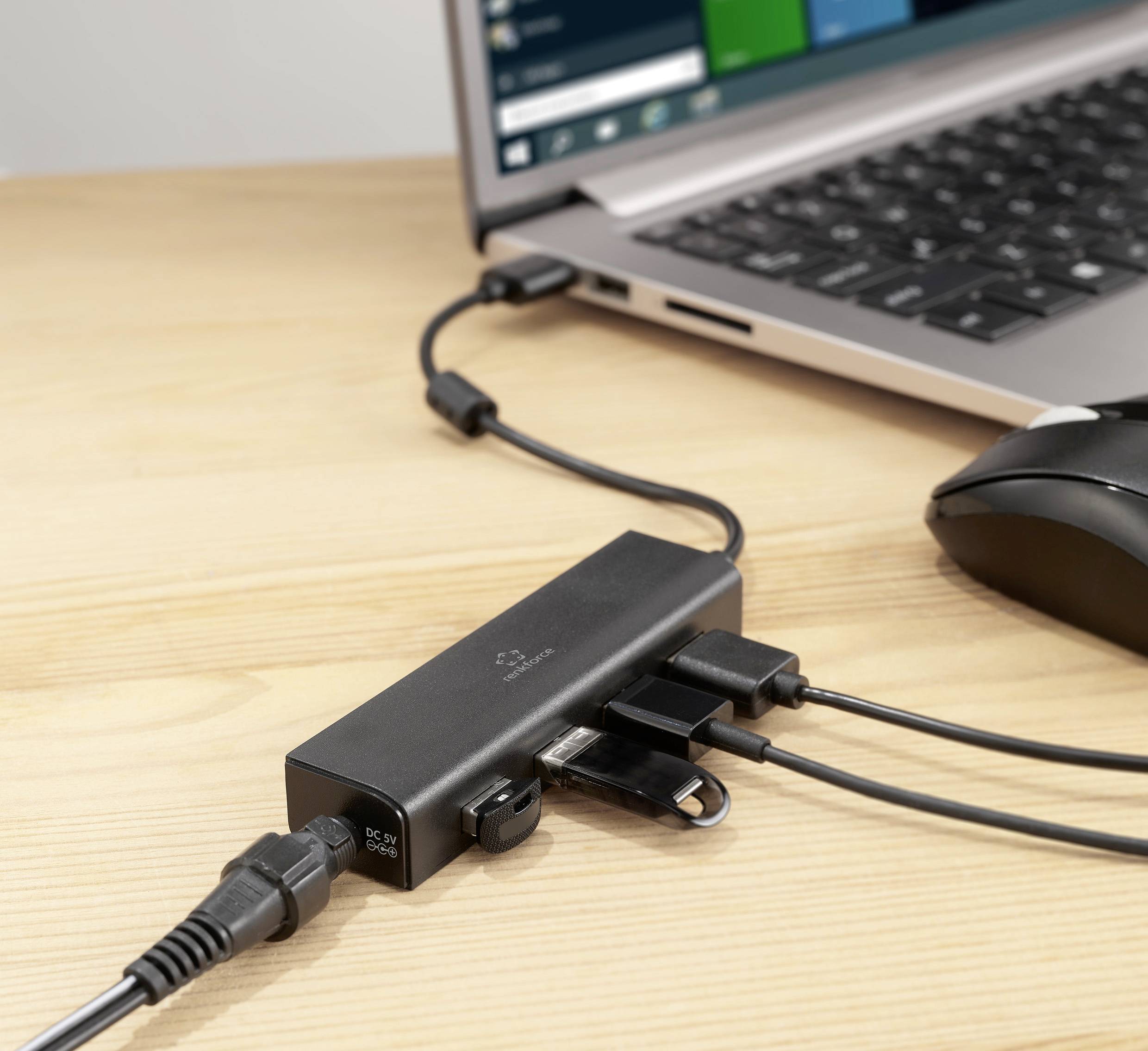 Een laptop is verbonden met een dockingstation dat meerdere kabelaansluitingen biedt. Er is ook een computermuis aangesloten.