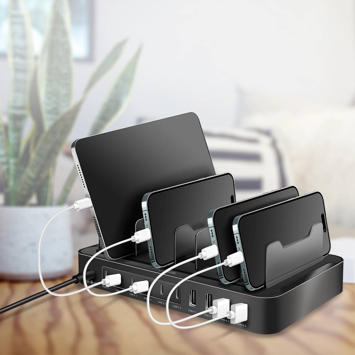Meerdere mobiele apparaten, waaronder smartphones en een tablet, worden gelijktijdig opgeladen op een compacte oplaadstandaard met meerdere USB-poorten.