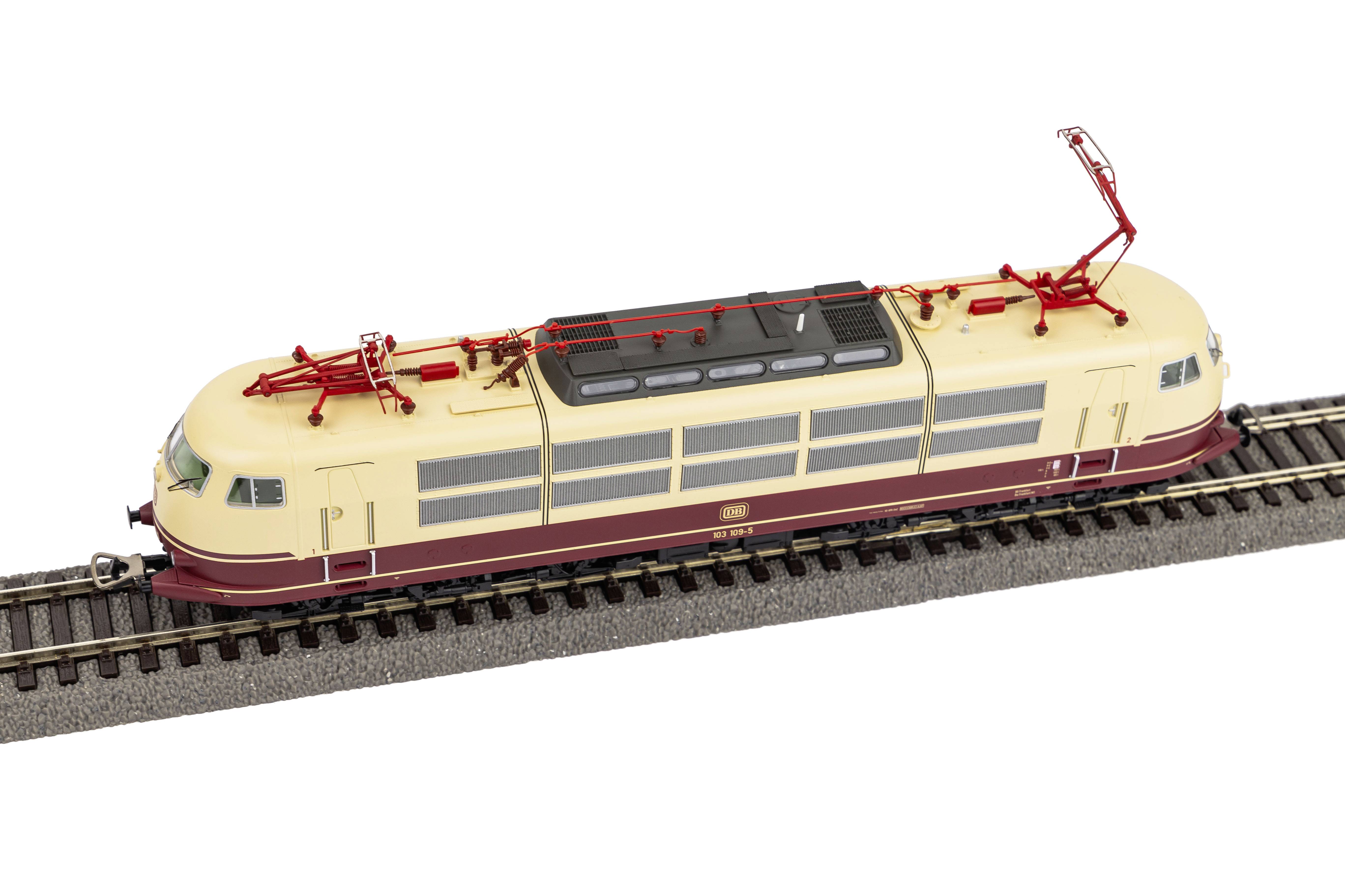 Een crème- en bordeauxrode modeltrein op een spoor toont een traditionele Duitse elektrische locomotief in zijaanzicht.
