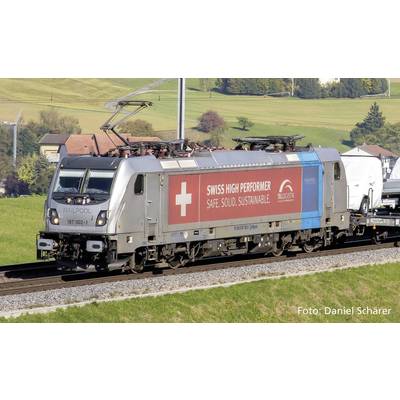Een zilveren locomotief van het bedrijf Railpool rijdt op een spoortraject. Op de zijkant staat 'Swiss High Performer: Veilig. Solide. Duurzaam.' in het rode veld.