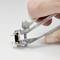 Een hand houdt een vergroot metalen nagelknipper vast. De knipper toont een gesloten snijvlak en een glanzend, zilverkleurig oppervlak.