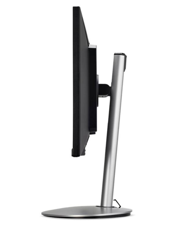 Een platte beeldschermmonitor van opzij, slank zilver design, gemonteerd op een ronde voet, moderne stijl.