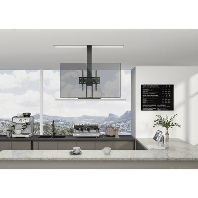 Moderne keuken met koffiezetapparaat, laptop op het aanrecht en uitzicht op bergen door grote ramen. Een menukaart hangt aan de muur.