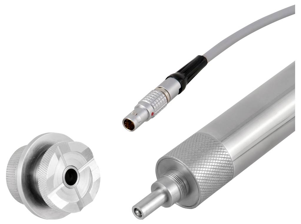 Een close-upfoto van een cilindrische metalen apparaat met een kabelaansluiting, waarbij technische details en afwerking gedetailleerd zichtbaar zijn.