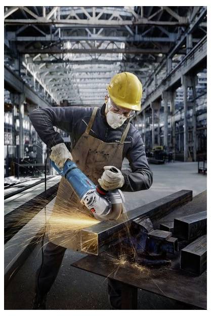Een arbeider in een fabriek slijpt een stalen balk met een elektrisch gereedschap, waarbij vonken rondvliegen. Hij draagt veiligheidsuitrusting, waaronder handschoenen, veiligheidsbril en een helm.