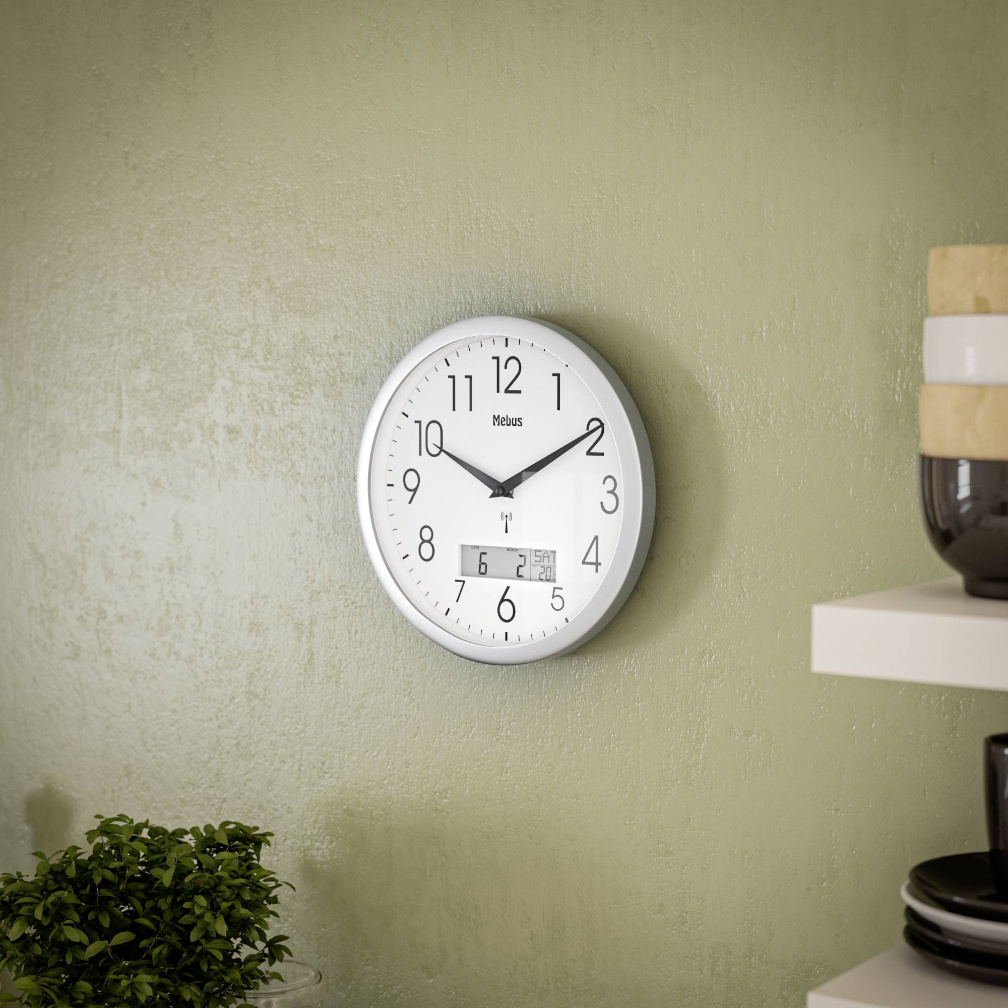 Een analoge wandklok met een witte achtergrond en zwarte cijfers, toont 10:09 uur. Op de voorgrond zijn een plant en vaas zichtbaar.