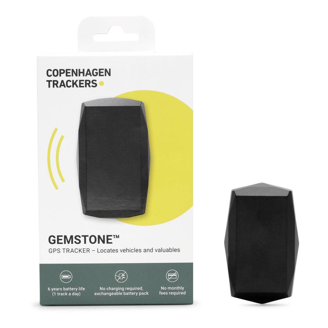 Verpakking van een GPS-tracker 'Copenhagen Trackers Gemstone'. Zwarte, gefacetteerde tracker ernaast. Tekst: 'Lokalisatie van voertuigen en waardevolle bezittingen'.
