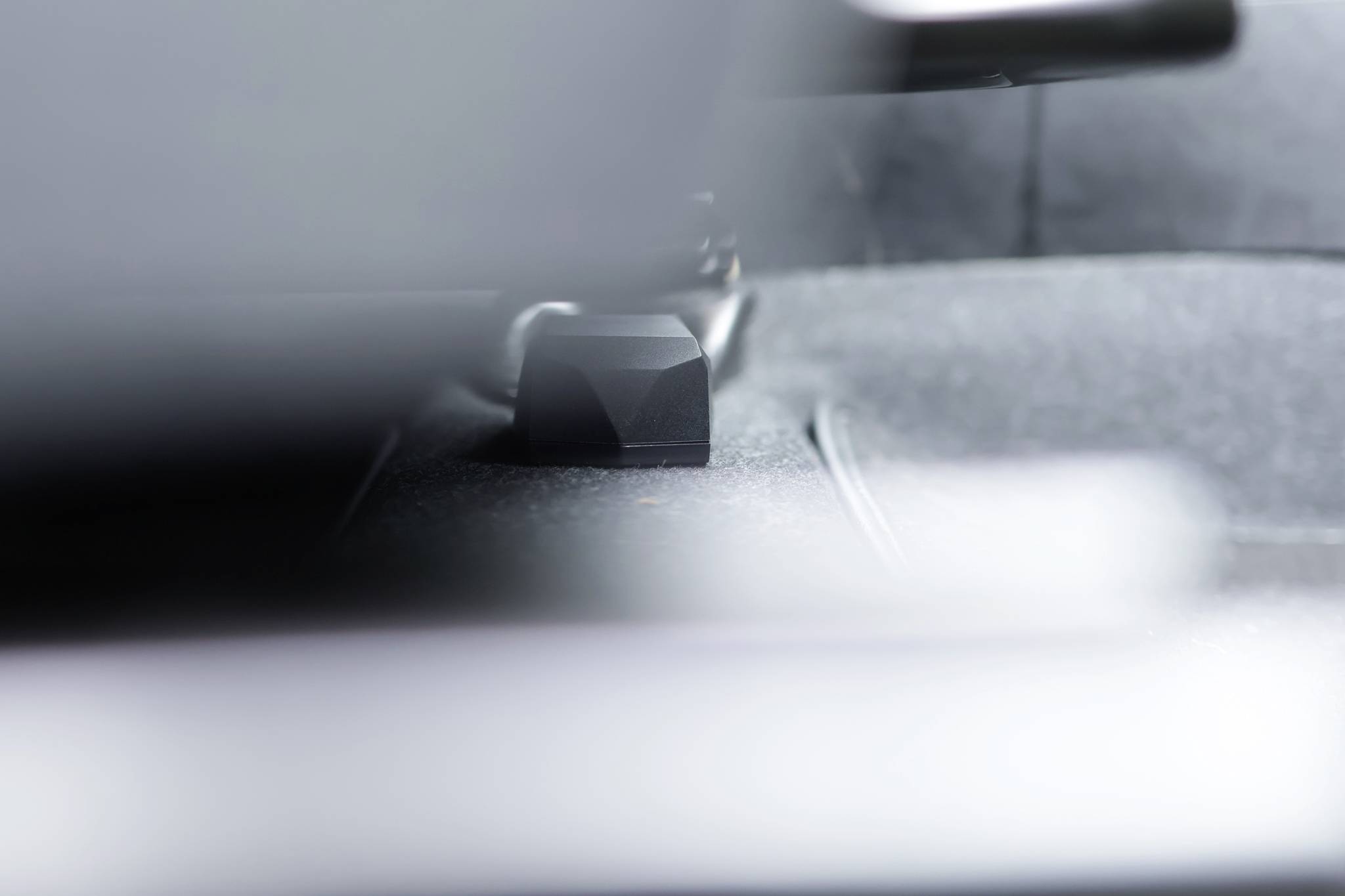 Een close-up van een onderdeel aan de binnenkant van een voertuig, waarschijnlijk een chassis-onderdeel. Onscherpe achtergrond, het hoofdobject staat scherp.