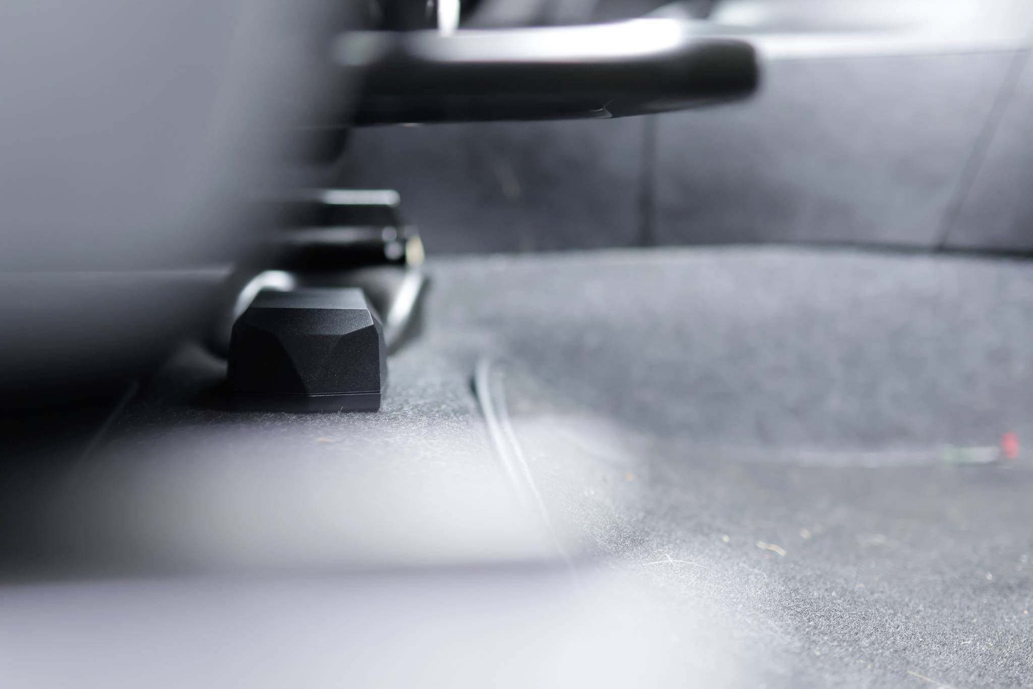 Wazig interieur van een auto, met focus op de vloerruimte tussen de voor- en achterbank.