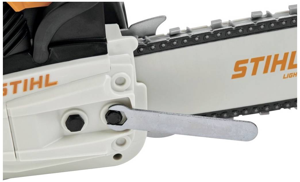 Close-up van een Stihl-kettingzaag in het wit, met een steeksleutel die is bevestigd aan de geleiderail voor het spannen van de ketting.
