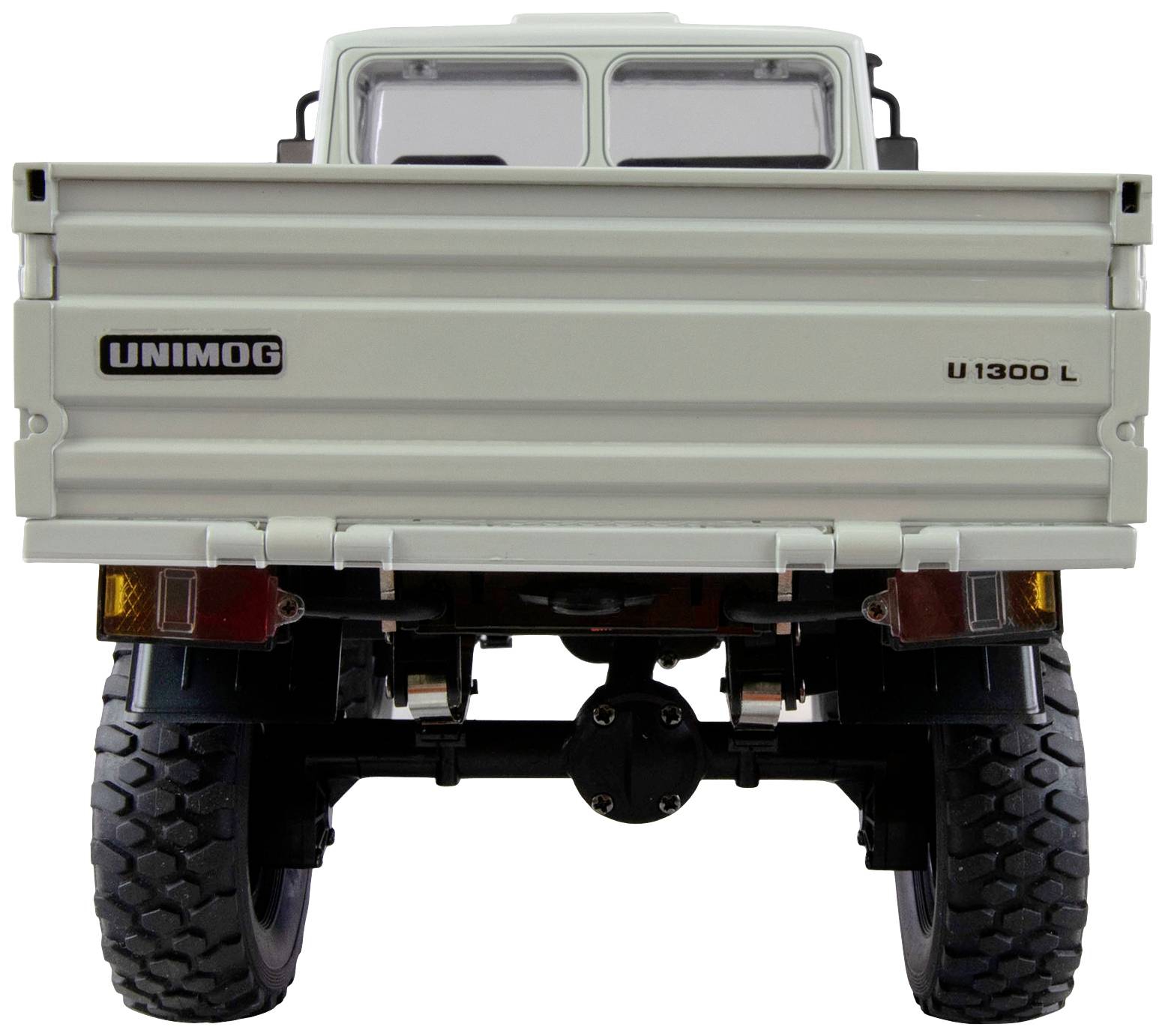 Achteraanzicht van een witte Unimog U1300 L-model met open laadruimtekleppen, robuuste banden en duidelijke voertuigdetails.