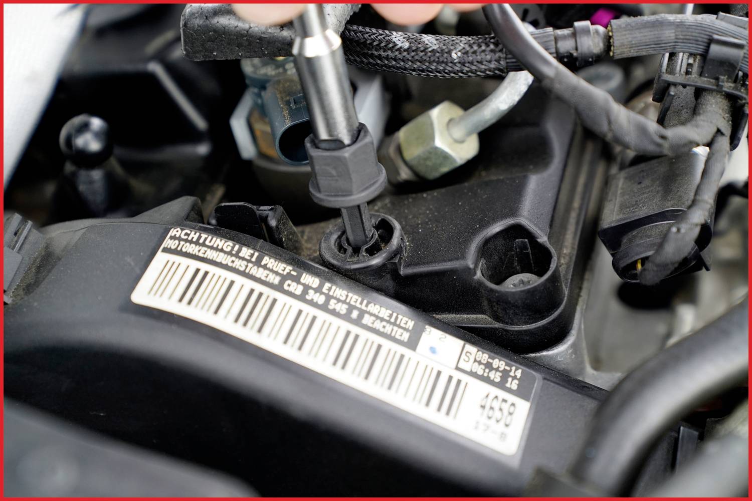 Een monteur werkt aan een onderdeel van een autoturbosysteem. Een barcode en serienummer zijn duidelijk zichtbaar.