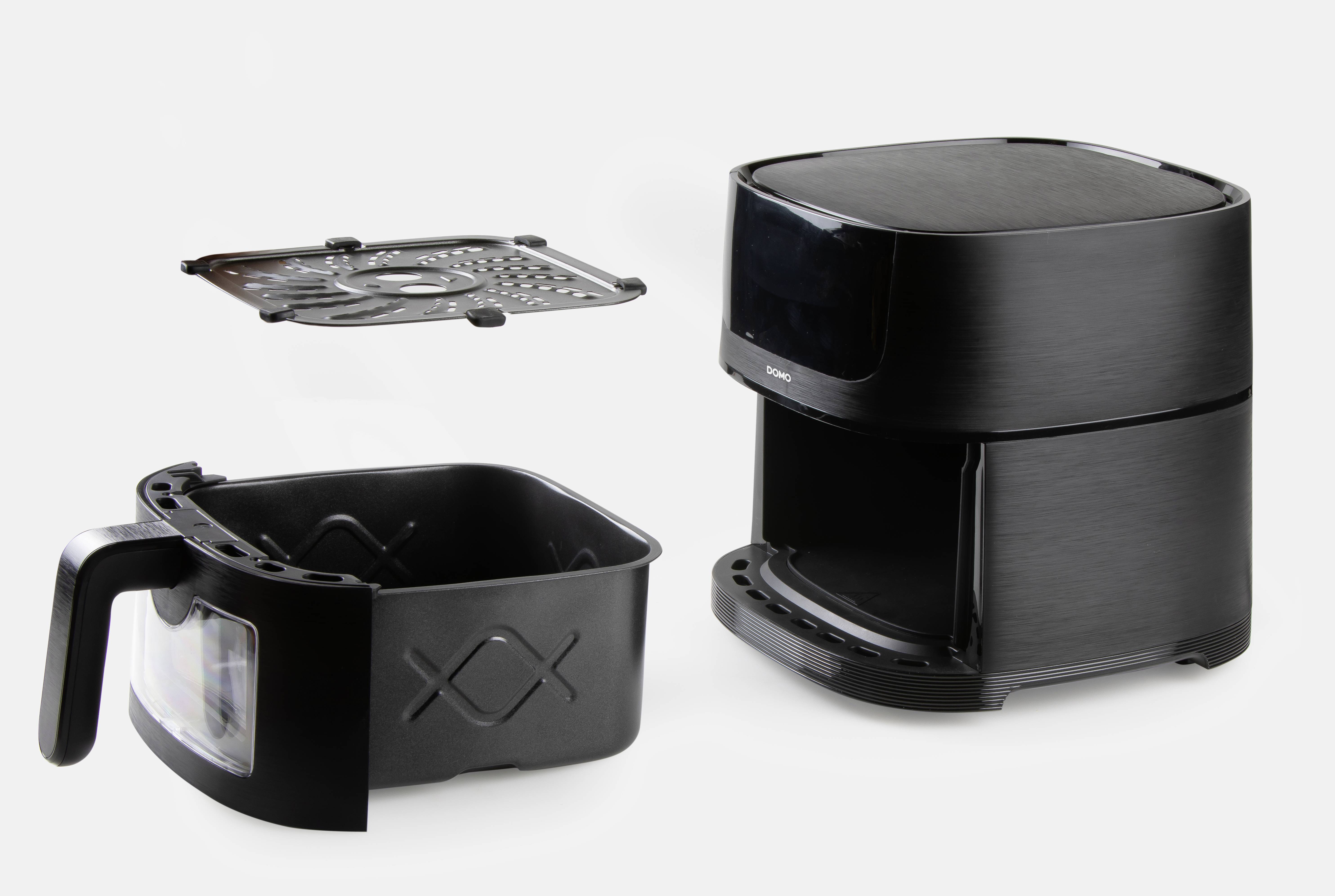 Een zwarte airfryer met uitgenomen mand en verwijderbaar rooster voor een lichtgrijze achtergrond.