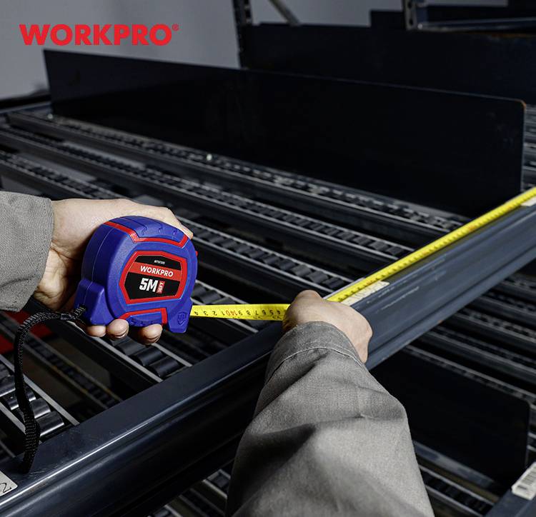 Een persoon meet een metalen rek met een geel meetlint. Het merk 'WORKPRO' is linksboven in het beeld zichtbaar.