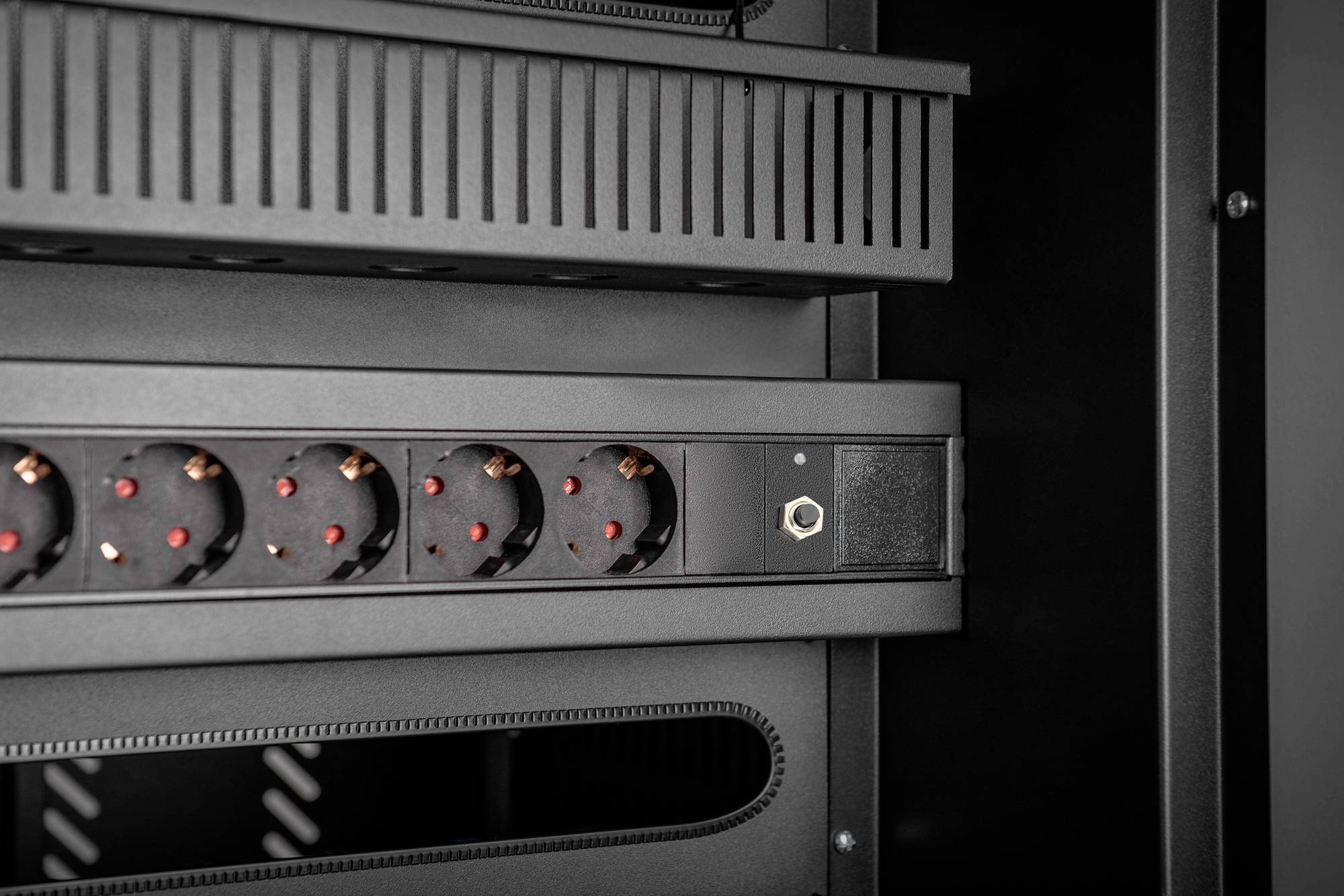 Een serverrek met meerdere stroomaansluitingen en ventilatierooster, gereed voor installatie van IT-apparatuur in een technische ruimte.