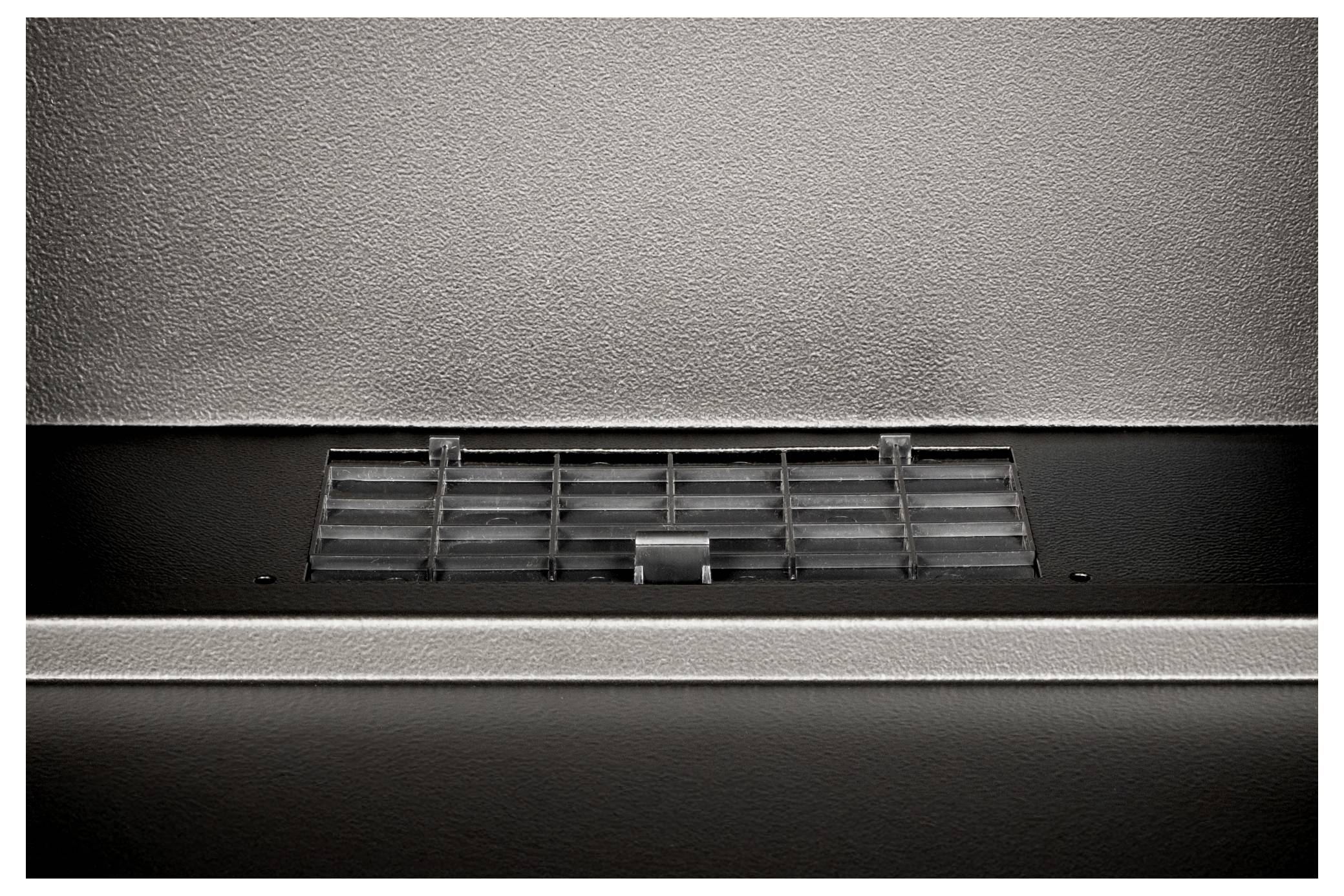 Ventilatierooster in een metalen oppervlak, centraal geplaatst.