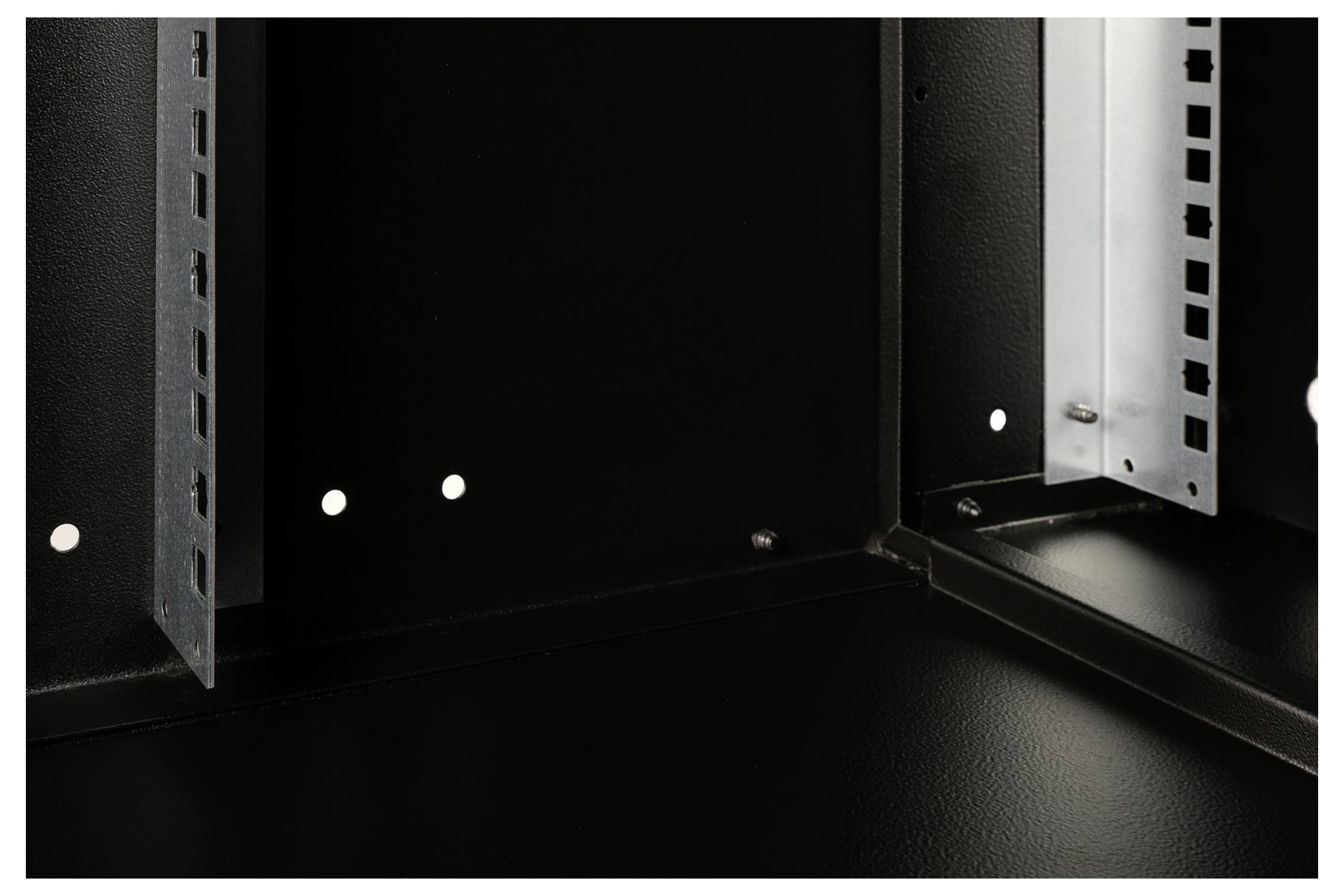 Een blik in het binnenste van een zwart metalen behuizing met open zijden, geschikt voor de installatie van IT-apparatuur of elektronische apparaten.