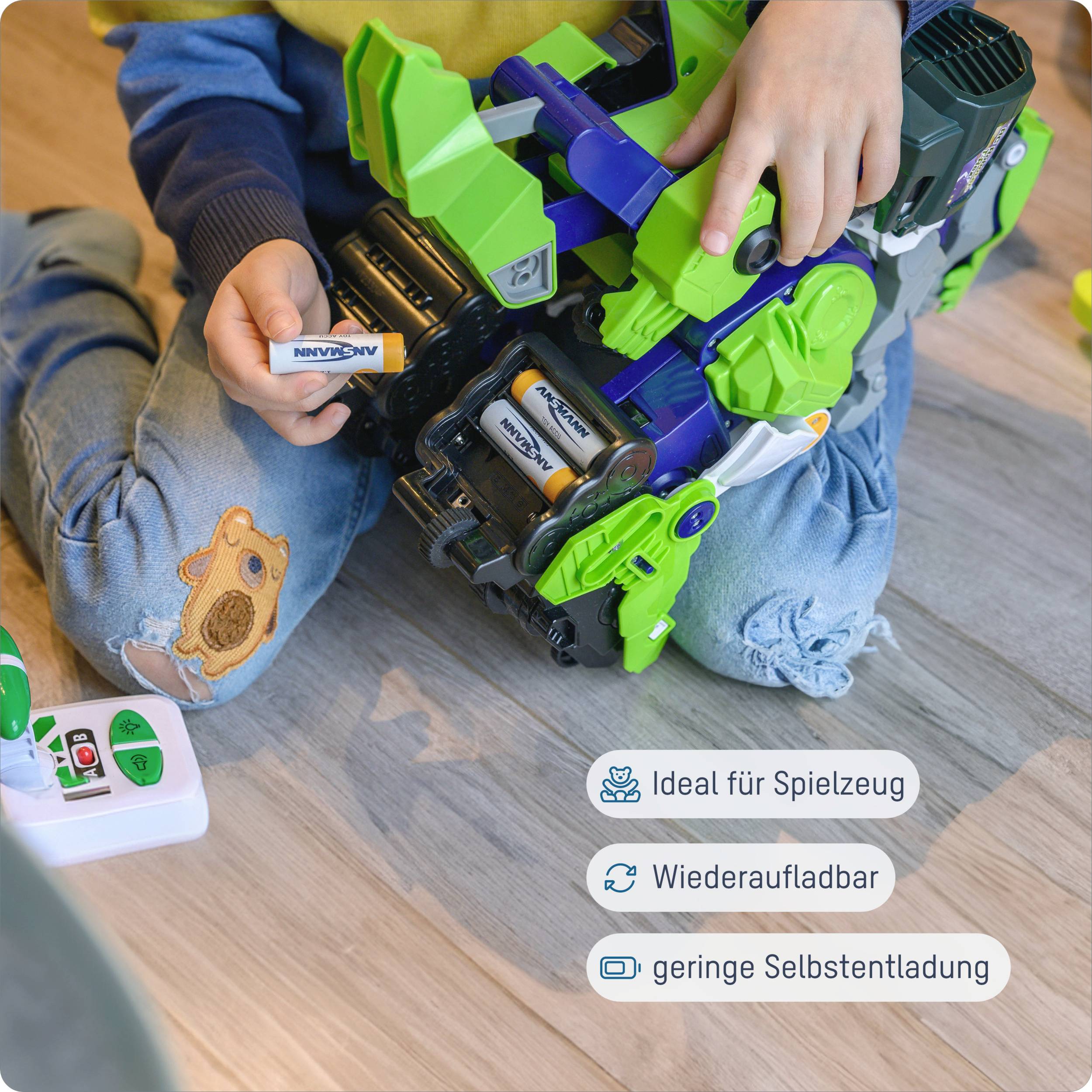 Een kind speelt op de grond met een groen-zwarte speelgoed-robot en houdt een oplaadbare batterij vast. Symbolen: Ideaal voor speelgoed, Oplaadbaar, Lage zelfontlading.