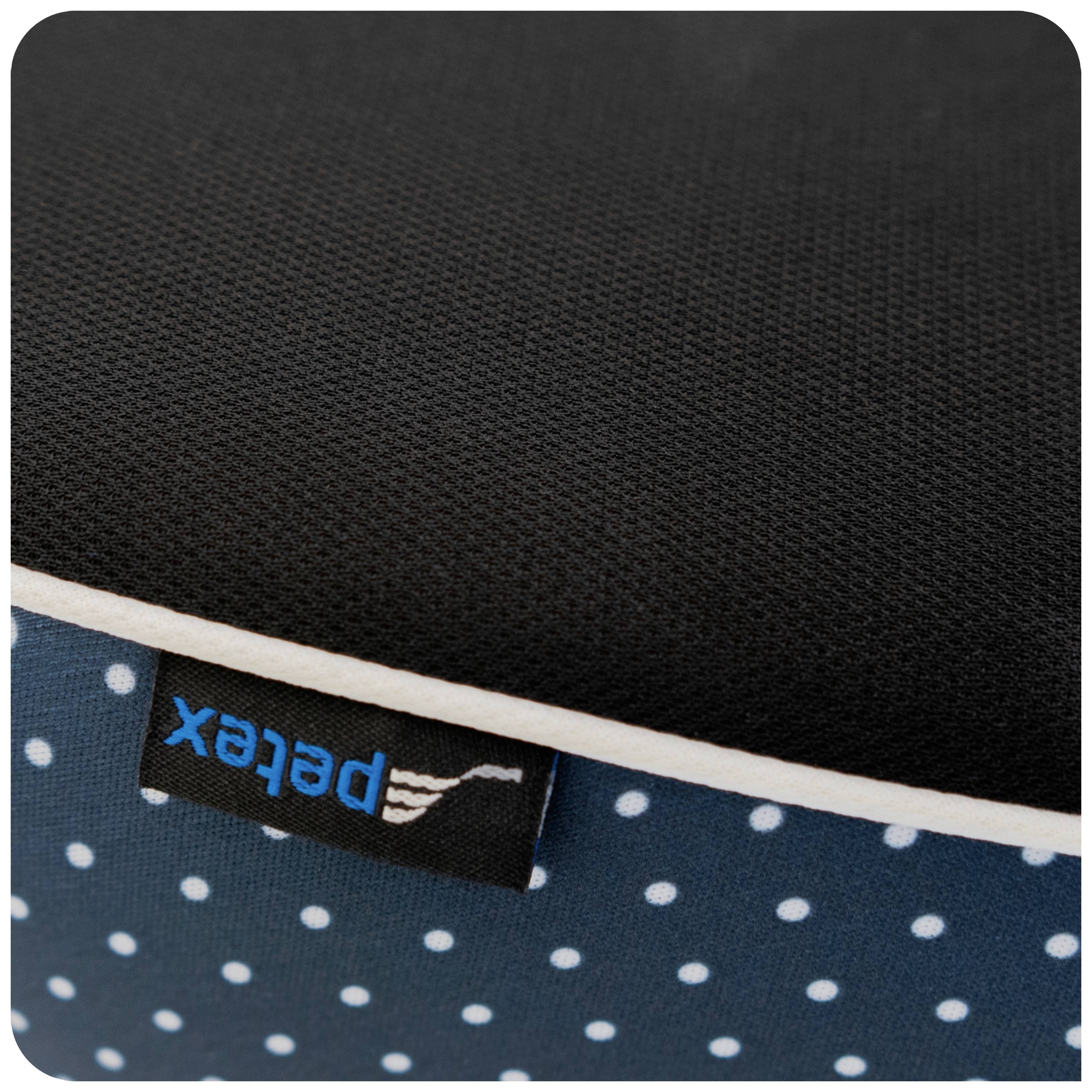 Een zwart-blauwe textiestof met witte stippen. Een klein etiket met de opdruk 'petex' is zichtbaar.